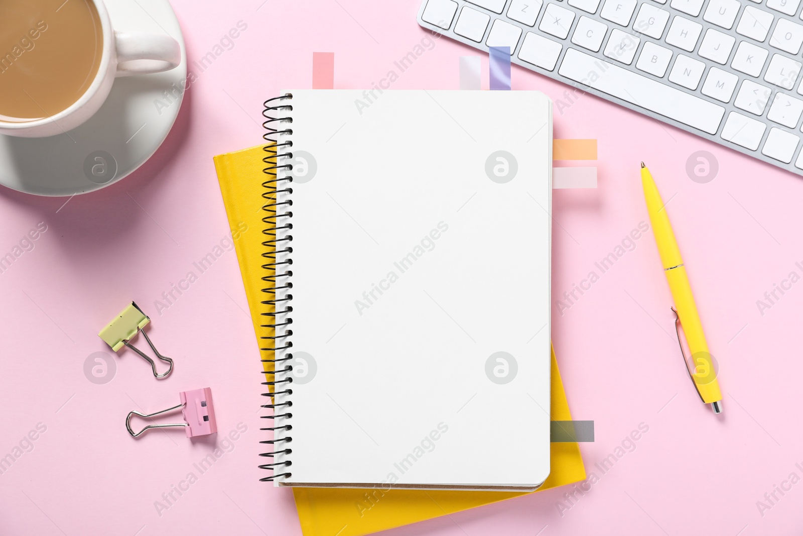 Open blank notebook with colorful stickers, other stationery, coffee and computer keyboard on pink background, flat lay Photo of Open blank notebook with colorful stickers, other stationery, coffee and computer keyboard on pink background, flat lay