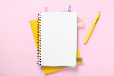 Photo of Open blank notebook with colorful stickers and pen on pink background, flat lay