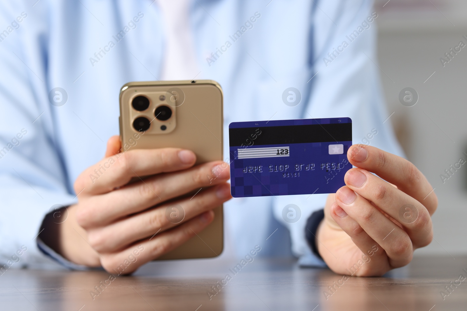 Photo of Woman with credit card and smartphone paying online at table, selective focus