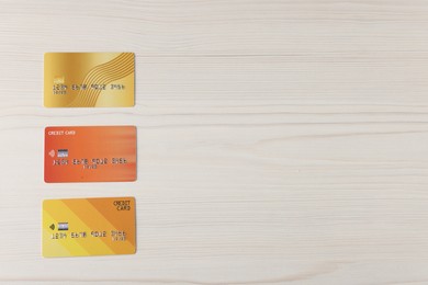 Photo of Online payment. Credit cards on light wooden table, flat lay. Space for text