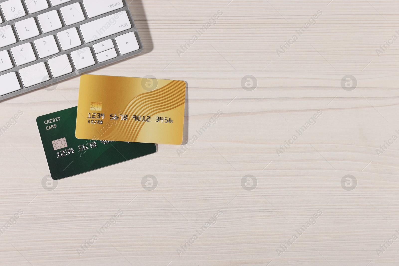 Online payment. Credit cards and computer keyboard on light wooden table, flat lay. Space for text Photo of Online payment. Credit cards and computer keyboard on light wooden table, flat lay. Space for text