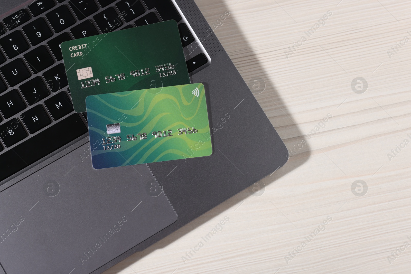 Online payment. Credit cards and laptop on light wooden table, top view. Space for text Photo of Online payment. Credit cards and laptop on light wooden table, top view. Space for text
