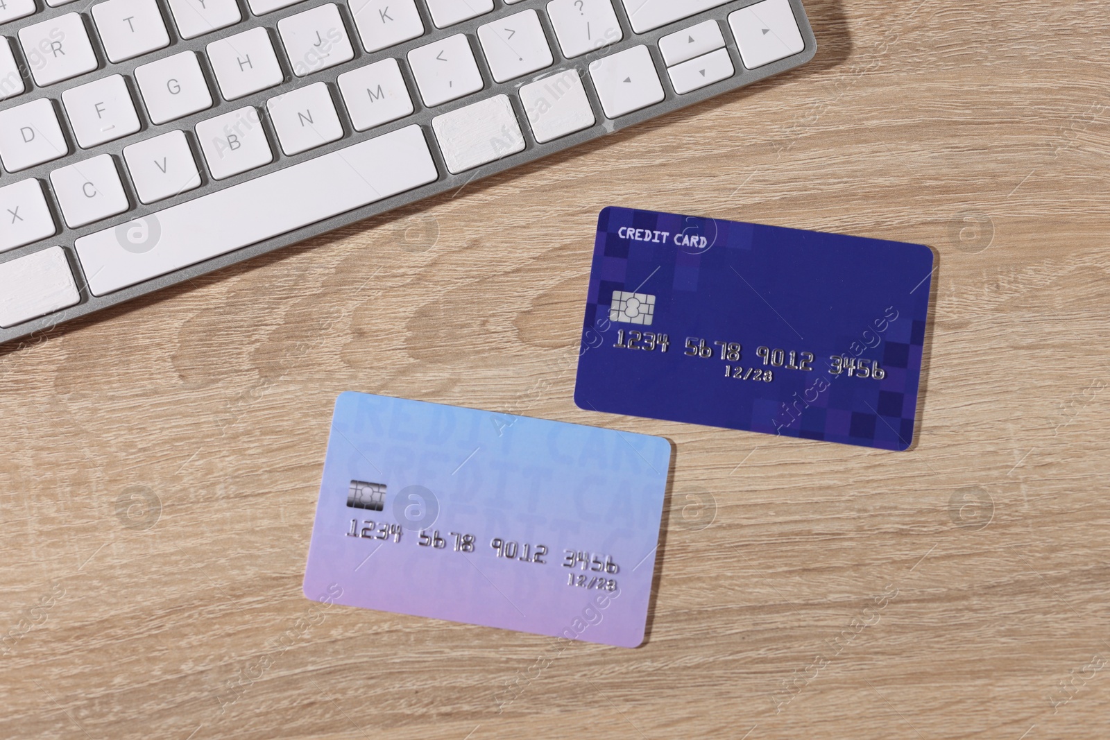 Online payment. Credit cards and computer keyboard on wooden table, flat lay Photo of Online payment. Credit cards and computer keyboard on wooden table, flat lay