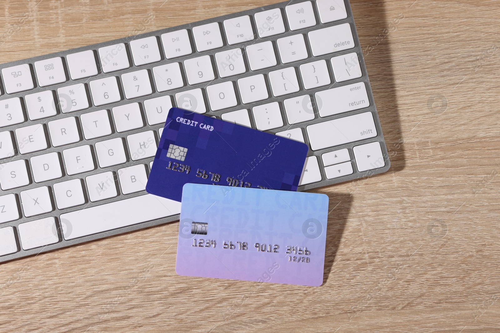 Photo of Online payment. Credit cards and computer keyboard on wooden table, top view