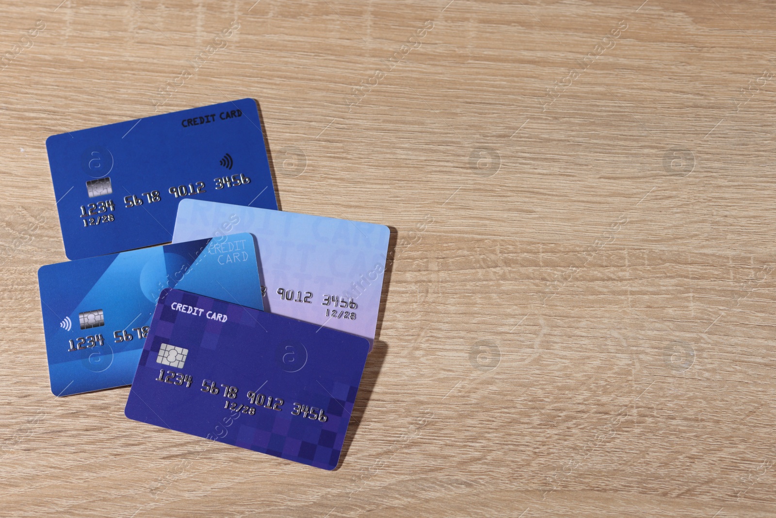 Photo of Online payment. Different credit cards on wooden table, top view. Space for text