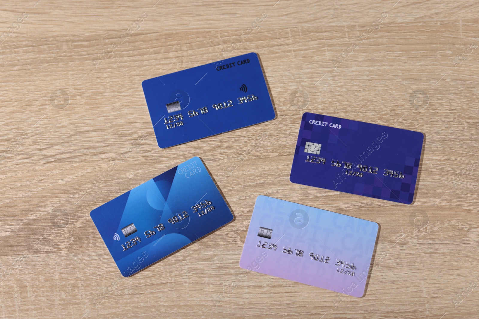 Photo of Online payment. Different credit cards on wooden table, flat lay