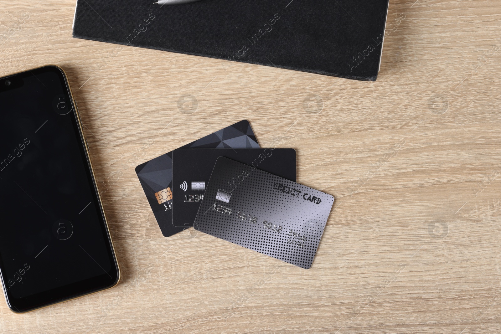 Photo of Online payment. Credit cards and smartphone on wooden table, flat lay