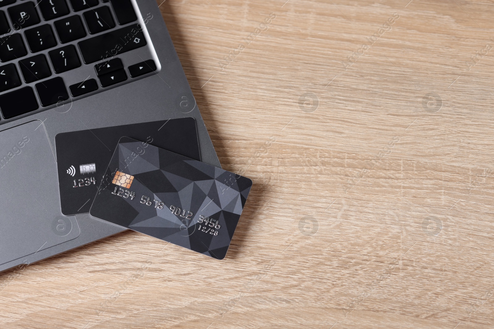 Online payment. Credit cards and laptop on wooden table, top view. Space for text Photo of Online payment. Credit cards and laptop on wooden table, top view. Space for text