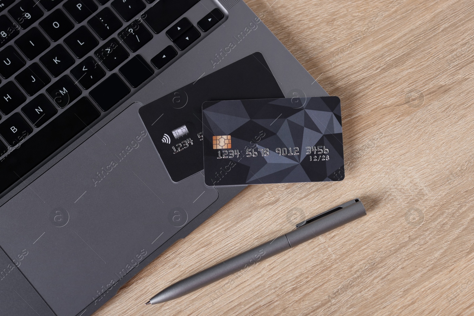 Online payment. Credit cards, laptop and pen on wooden table, flat lay Photo of Online payment. Credit cards, laptop and pen on wooden table, flat lay