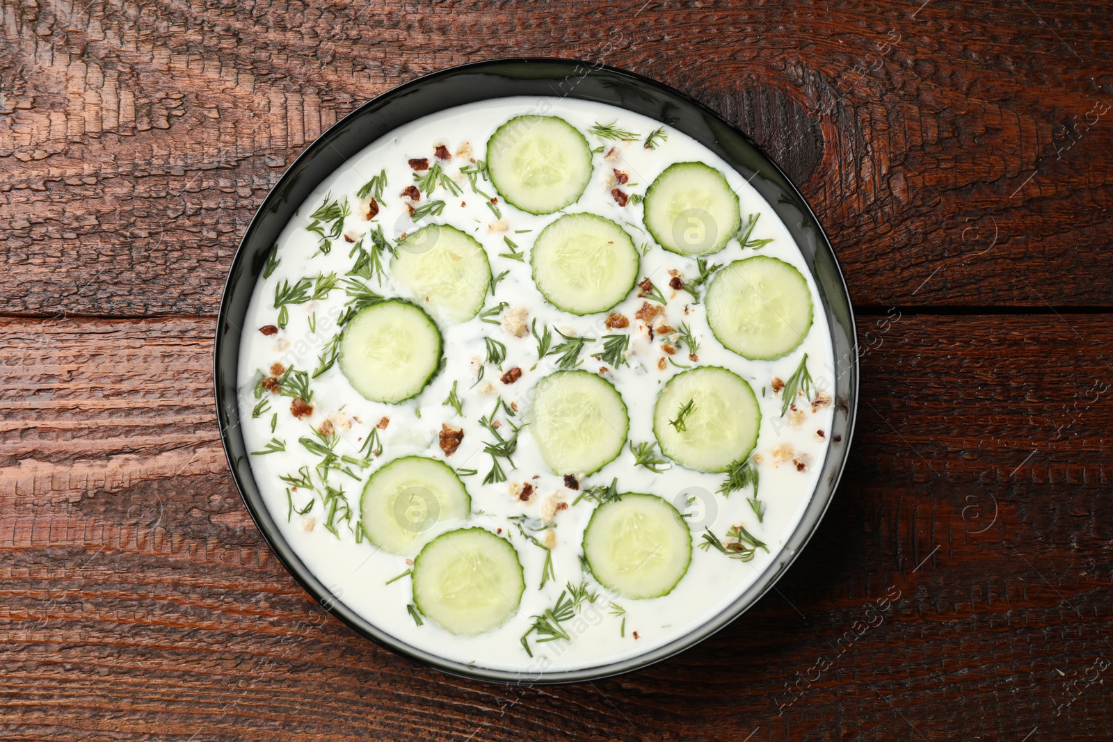 Fresh tasty cucumber soup on wooden table, top view Photo of Fresh tasty cucumber soup on wooden table, top view