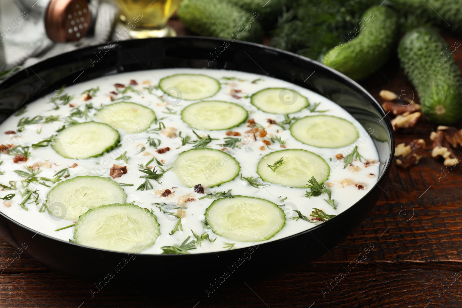 Fresh tasty cucumber soup and ingredients on wooden table, closeup Photo of Fresh tasty cucumber soup and ingredients on wooden table, closeup