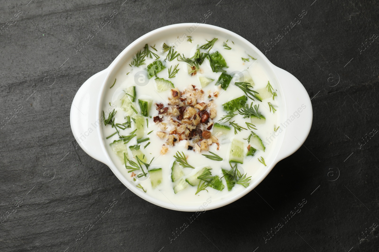 Fresh tasty cucumber soup on black table, top view Photo of Fresh tasty cucumber soup on black table, top view
