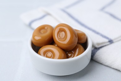 Photo of Tasty sweet caramel candies on white table, closeup