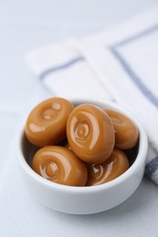 Photo of Tasty sweet caramel candies on white table, closeup