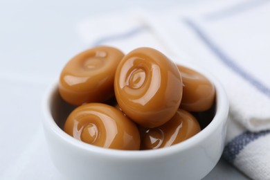 Photo of Tasty sweet caramel candies on white table, closeup