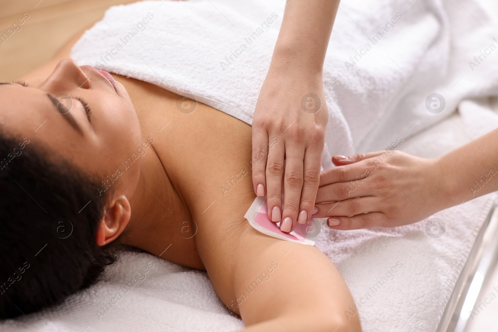 Woman undergoing wax epilation procedure indoors, closeup Photo of Woman undergoing wax epilation procedure indoors, closeup