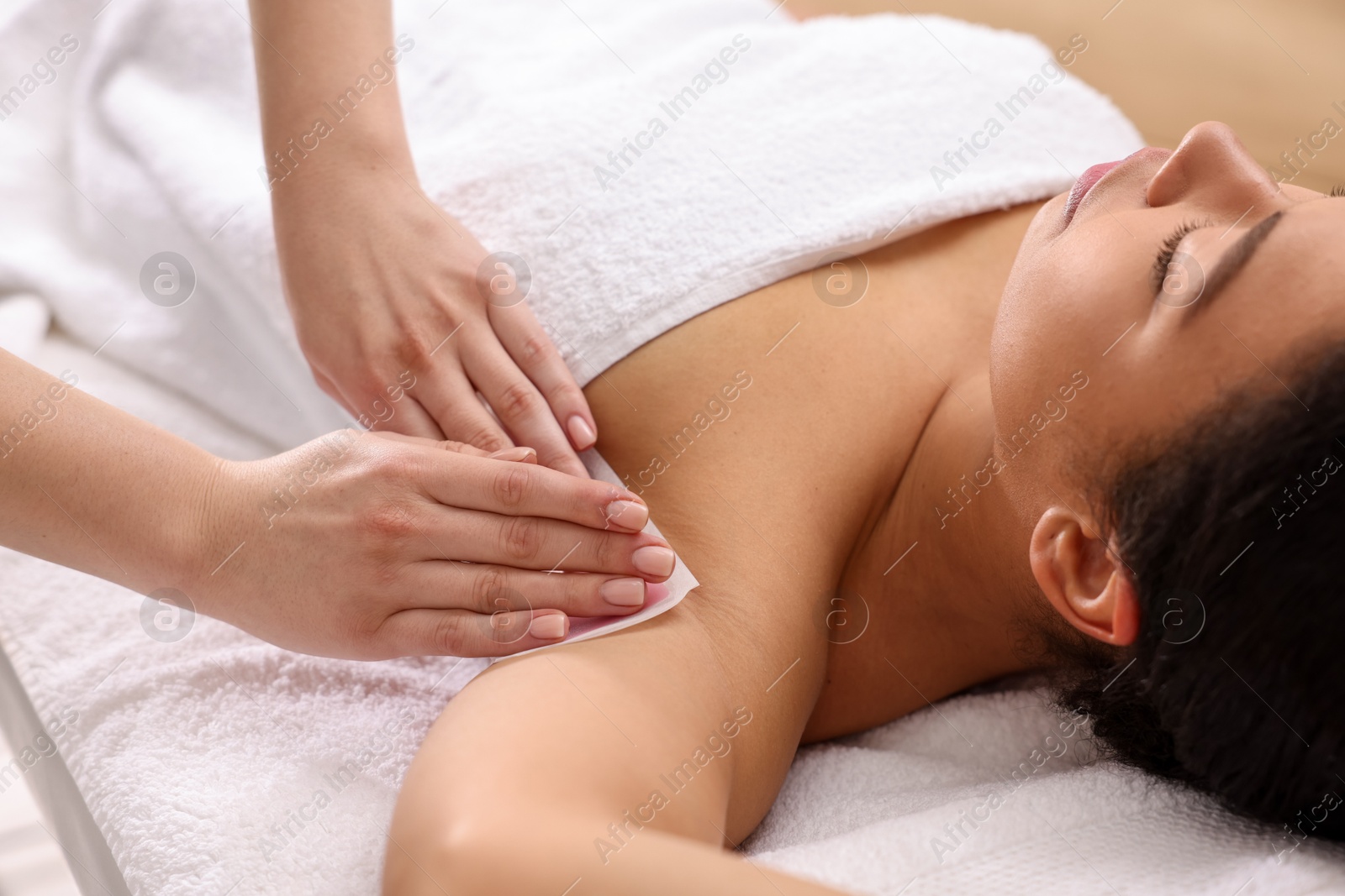 Woman undergoing wax epilation procedure indoors, closeup Photo of Woman undergoing wax epilation procedure indoors, closeup