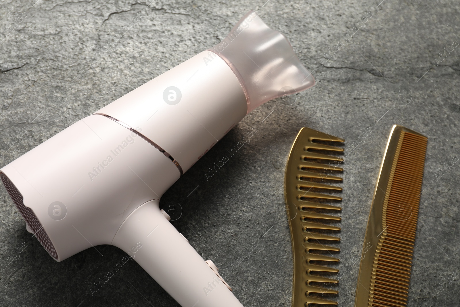 Different hairstyling tools on grey textured background, closeup Photo of Different hairstyling tools on grey textured background, closeup