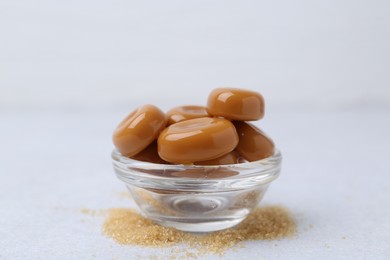 Photo of Tasty sweet caramel candies on white table, closeup