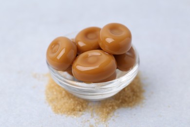 Photo of Tasty sweet caramel candies on white table, closeup