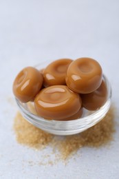 Photo of Tasty sweet caramel candies on white table, closeup