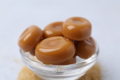 Photo of Tasty sweet caramel candies on white table, closeup