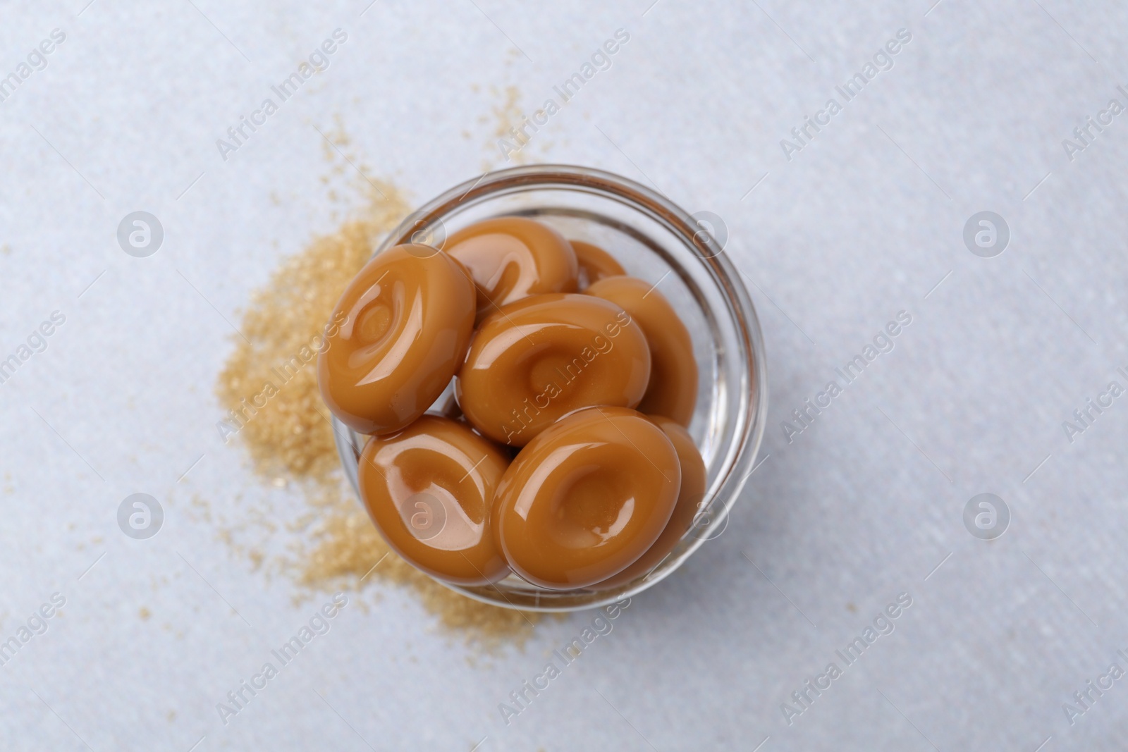 Tasty sweet caramel candies on white table, top view Photo of Tasty sweet caramel candies on white table, top view