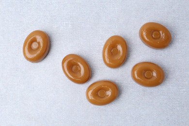 Photo of Tasty sweet caramel candies on white table, flat lay