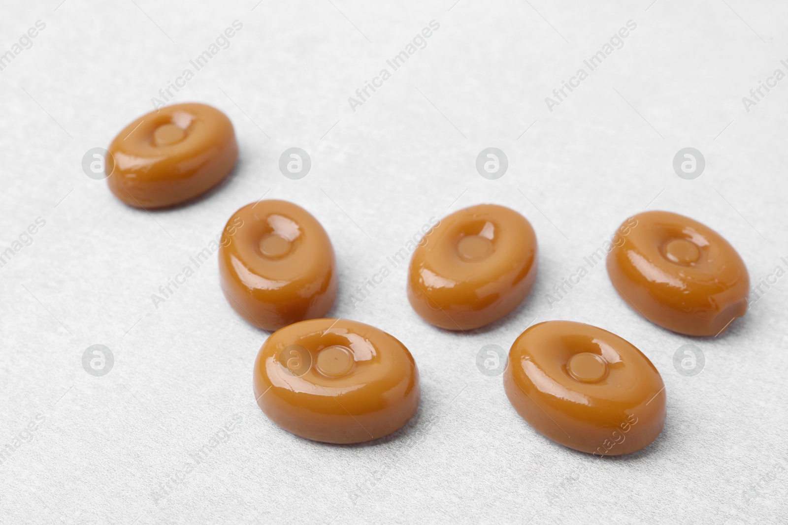 Tasty sweet caramel candies on white table, closeup Photo of Tasty sweet caramel candies on white table, closeup