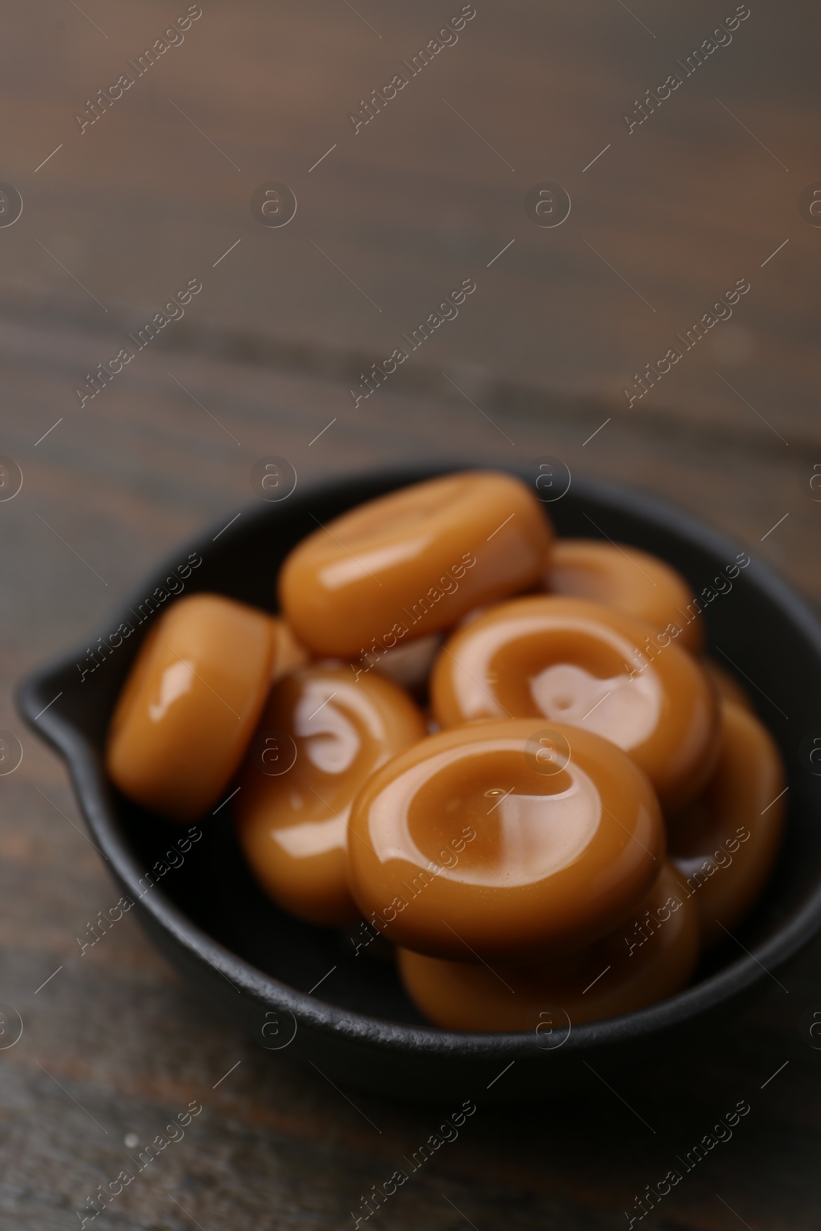 Tasty sweet caramel candies on wooden table, closeup Photo of Tasty sweet caramel candies on wooden table, closeup