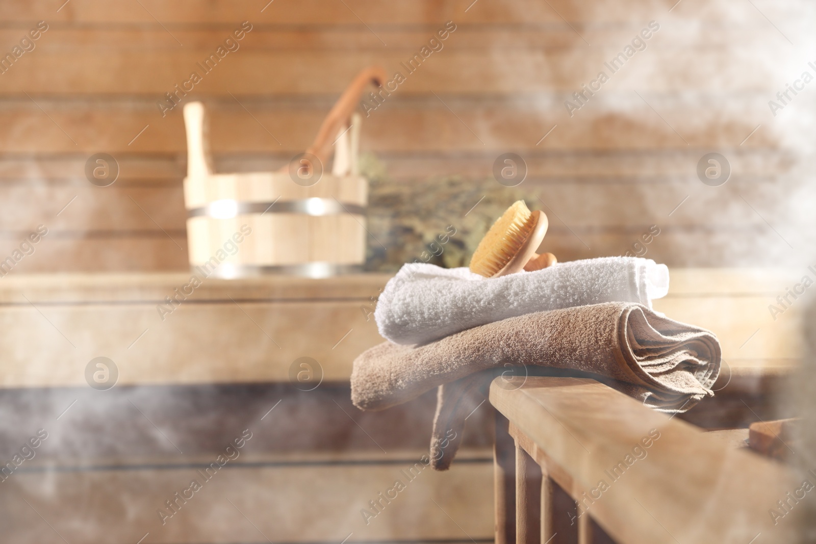 Massaging brush, towels and other care supplies surrounded by steam in sauna Image of Massaging brush, towels and other care supplies surrounded by steam in sauna