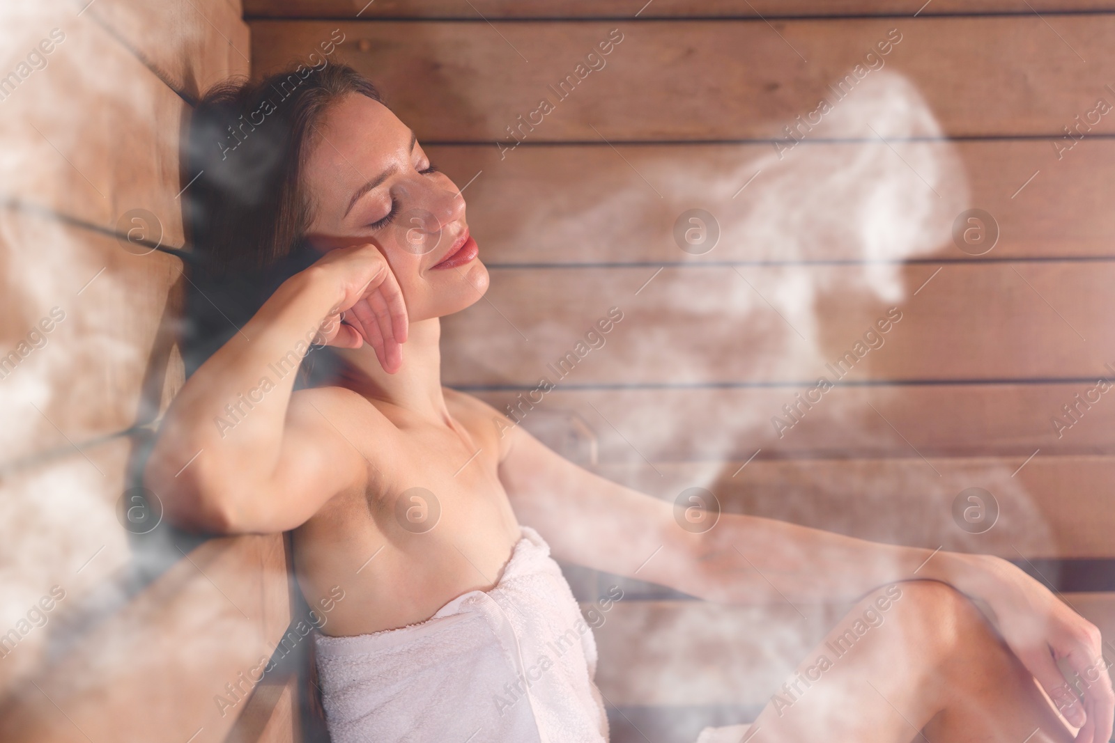 Beautiful woman relaxing surrounded by steam in sauna Image of Beautiful woman relaxing surrounded by steam in sauna