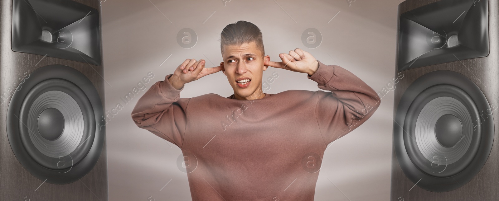 Annoyed man covering his ears from loud sound of audio speakers on beige grey background Image of Annoyed man covering his ears from loud sound of audio speakers on beige grey background