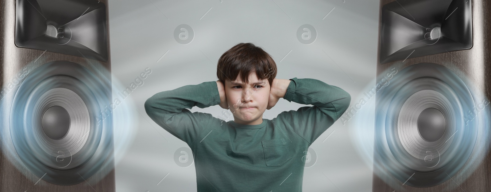 Annoyed boy covering his ears from loud sound of audio speakers on grey background Image of Annoyed boy covering his ears from loud sound of audio speakers on grey background