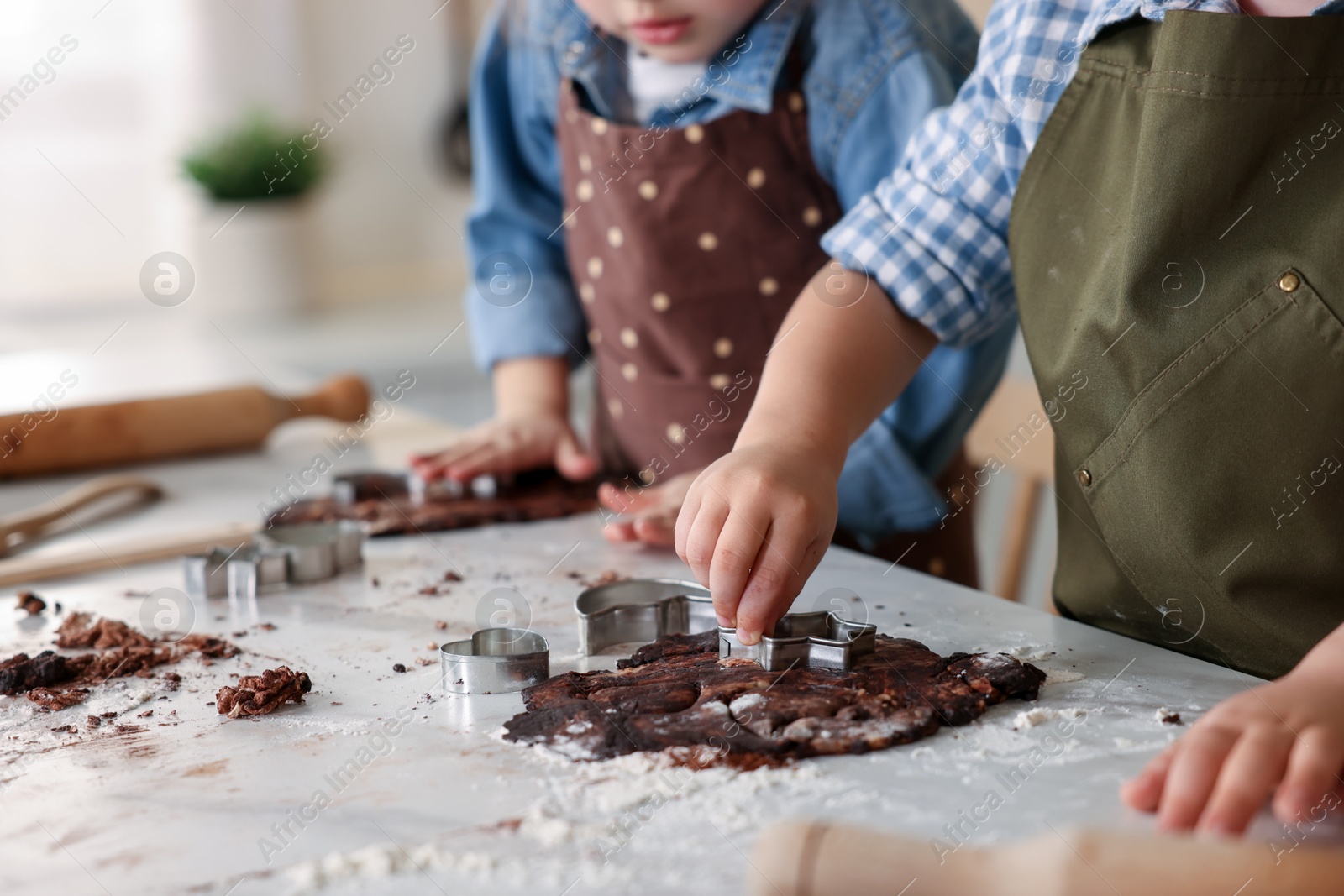 Cooking recipe. Little children cutting cookie dough with cutters at table indoors, closeup Photo of Cooking recipe. Little children cutting cookie dough with cutters at table indoors, closeup