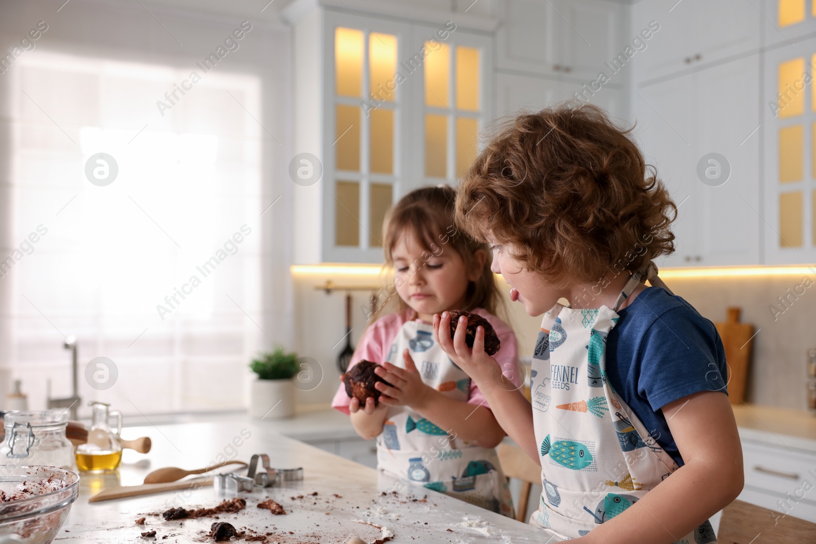 Cooking recipe. Little children making dough for cookies at table in kitchen. Space for text Photo of Cooking recipe. Little children making dough for cookies at table in kitchen. Space for text
