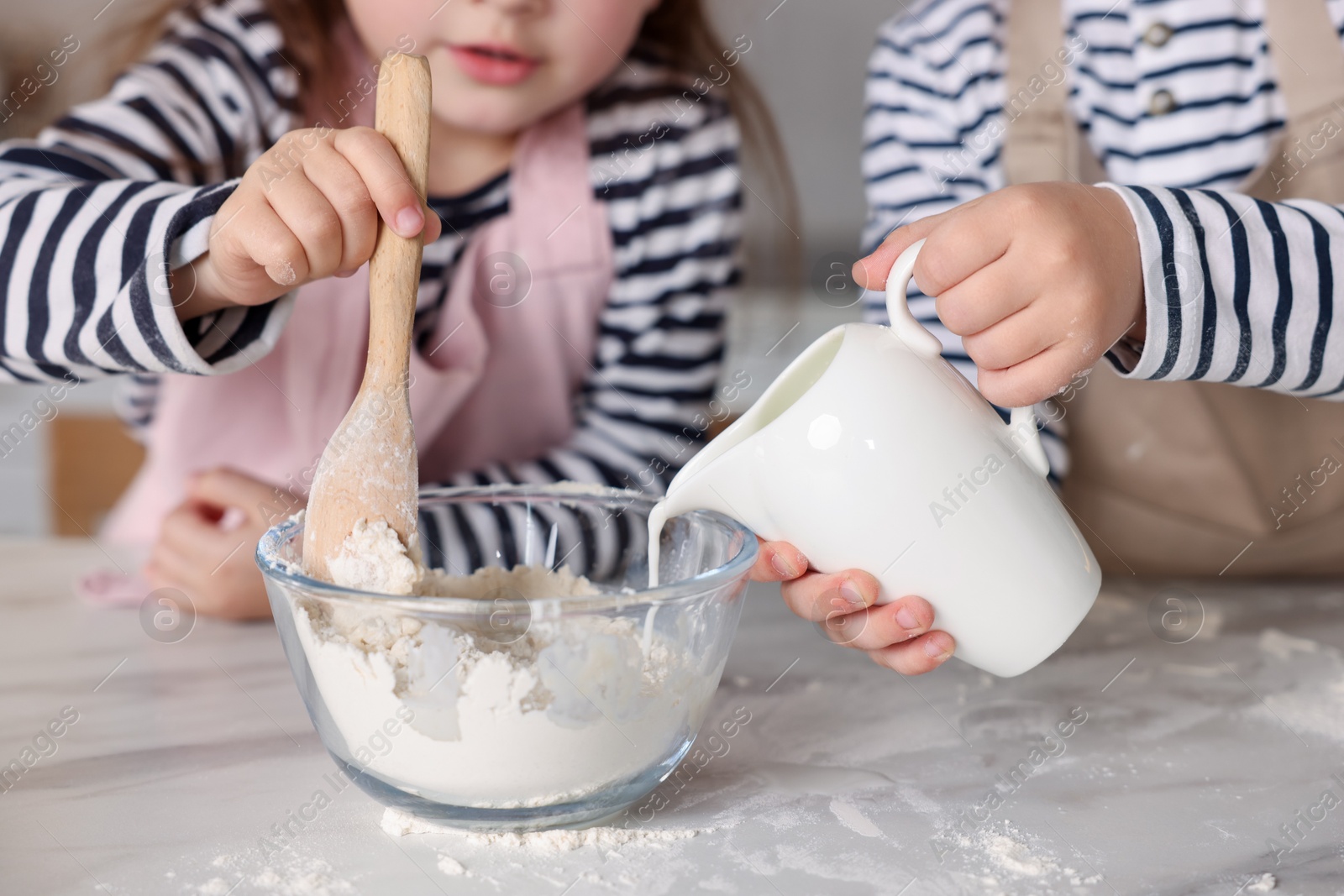 Cooking recipe. Cute children making dough for cookies at table in kitchen, closeup Photo of Cooking recipe. Cute children making dough for cookies at table in kitchen, closeup
