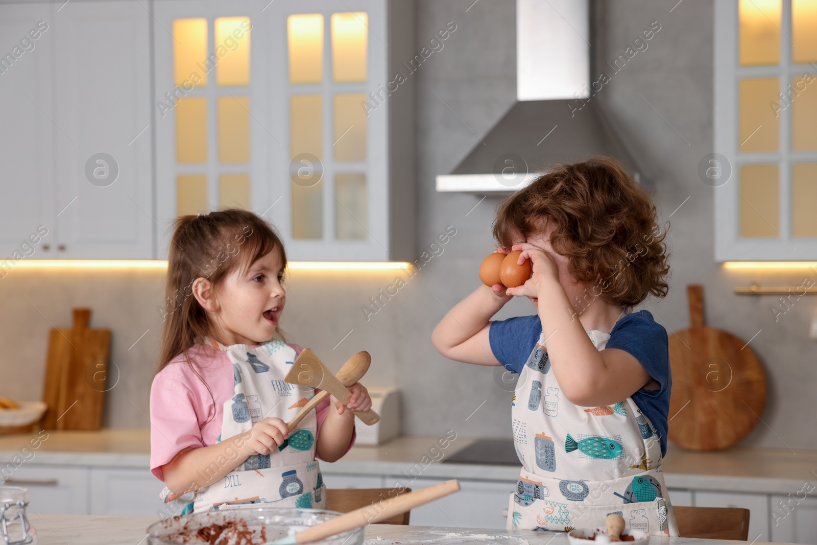 Cooking recipe. Little children making dough for cookies at table in kitchen Photo of Cooking recipe. Little children making dough for cookies at table in kitchen
