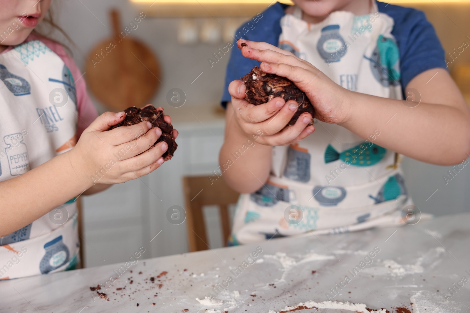 Cooking recipe. Little children making dough for cookies at table in kitchen, closeup Photo of Cooking recipe. Little children making dough for cookies at table in kitchen, closeup