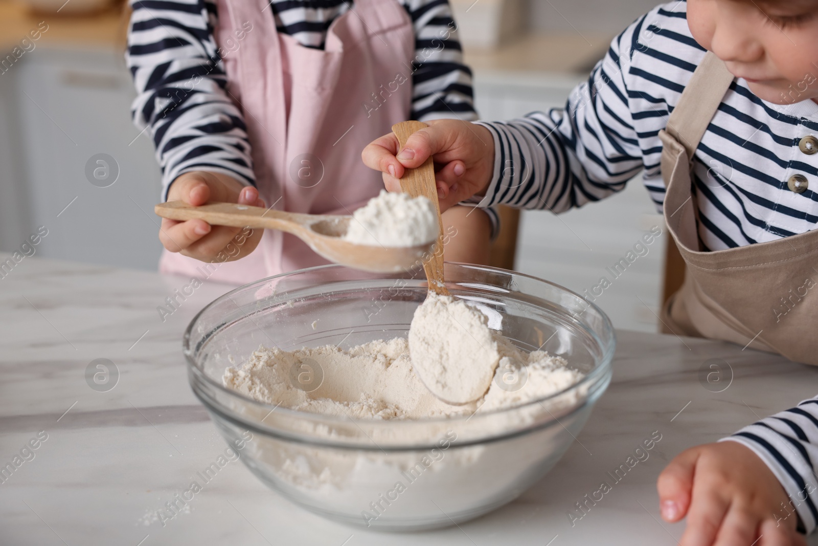 Cooking recipe. Little children making dough for cookies at table in kitchen, closeup Photo of Cooking recipe. Little children making dough for cookies at table in kitchen, closeup