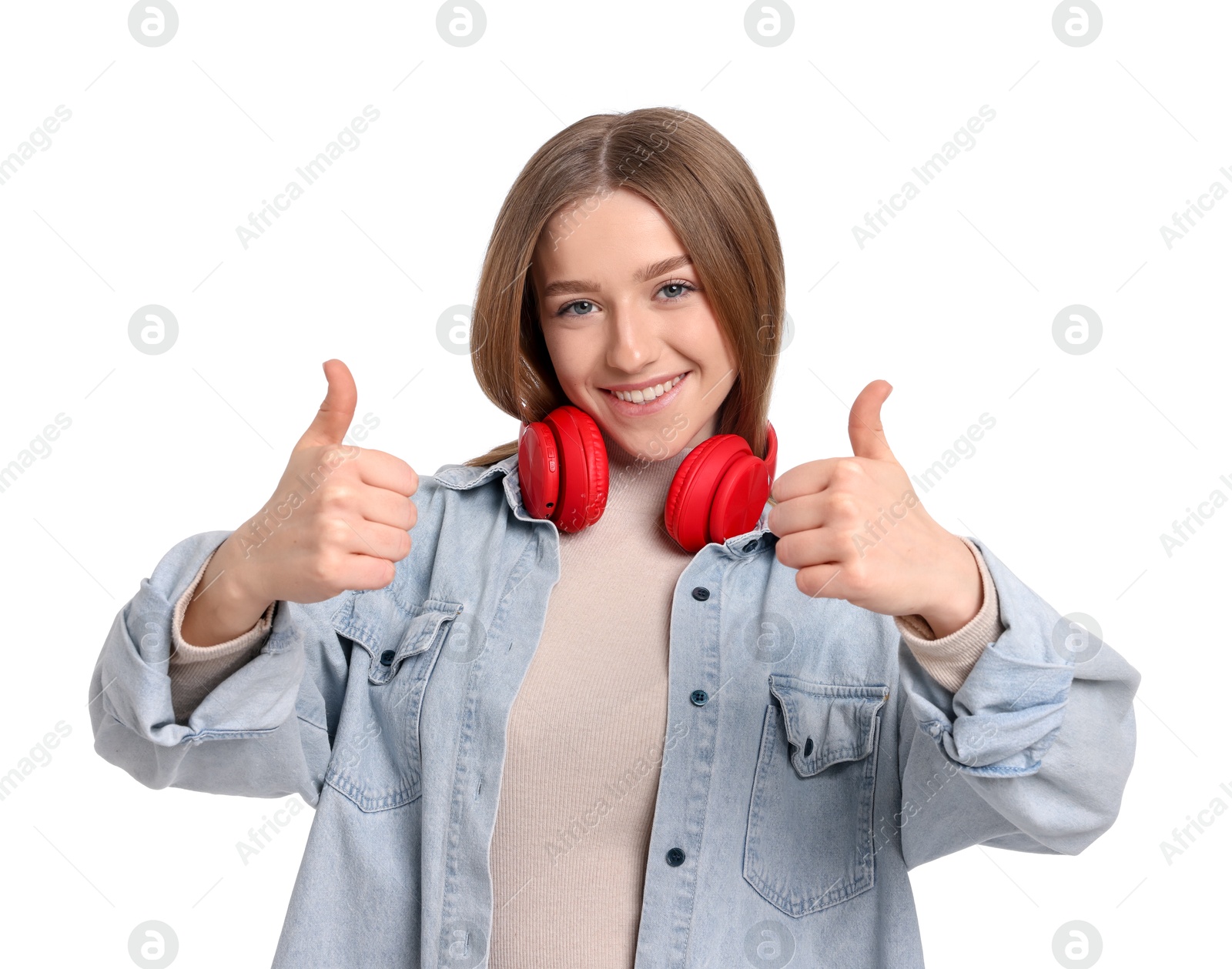 Portrait of smiling teenage girl showing thumbs up on white background Photo of Portrait of smiling teenage girl showing thumbs up on white background