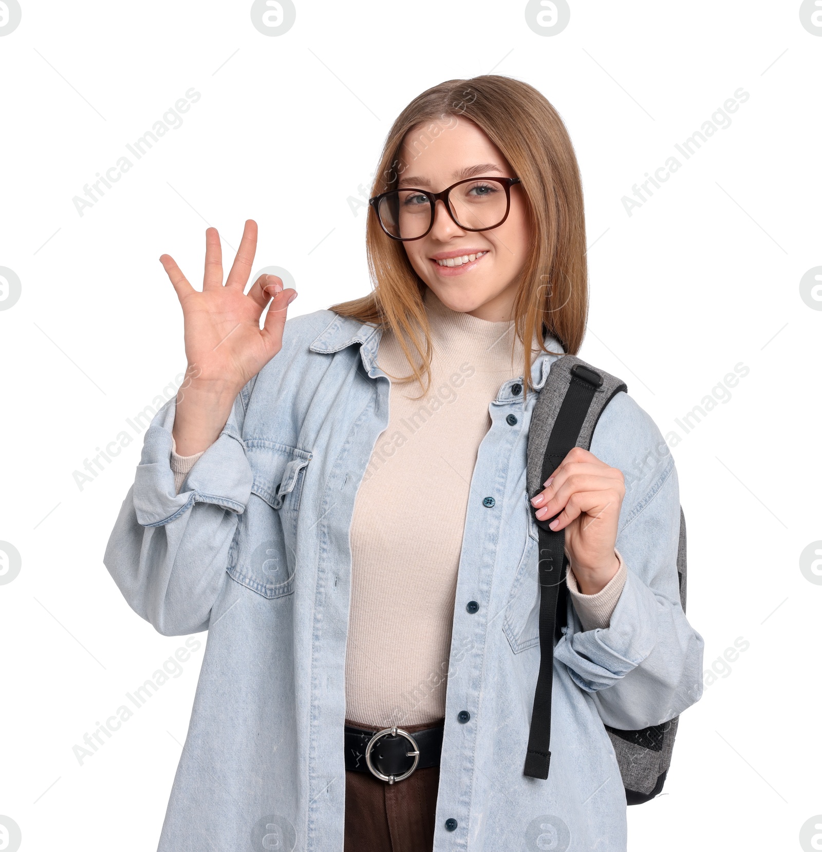 Photo of Smiling teenage girl with backpack showing ok gesture on white background