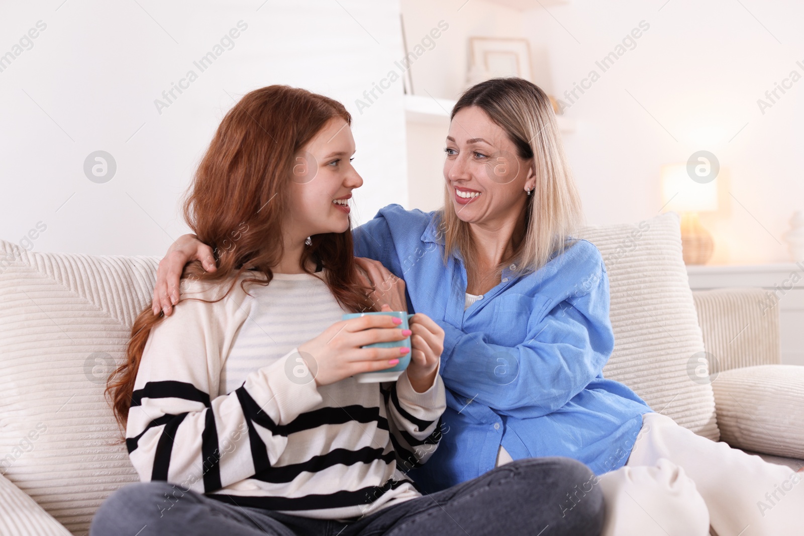 Mother and her daughter on sofa at home Photo of Mother and her daughter on sofa at home