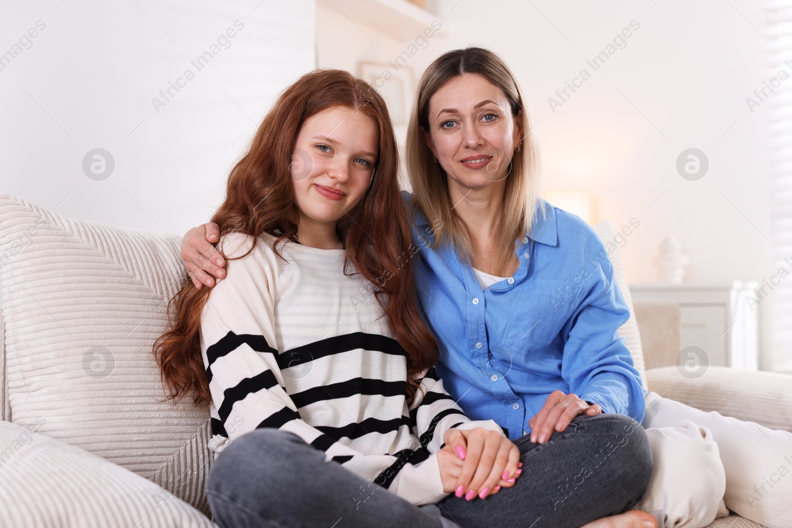 Mother and her daughter on sofa at home Photo of Mother and her daughter on sofa at home