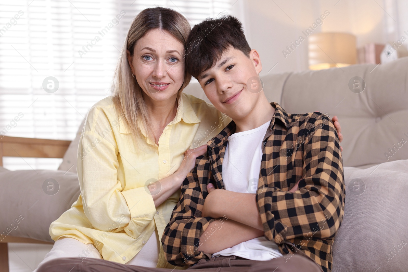 Mother and her son near sofa at home Photo of Mother and her son near sofa at home