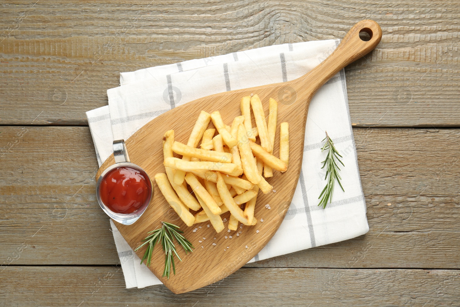Tasty french fries with ketchup and rosemary on wooden table, top view Photo of Tasty french fries with ketchup and rosemary on wooden table, top view