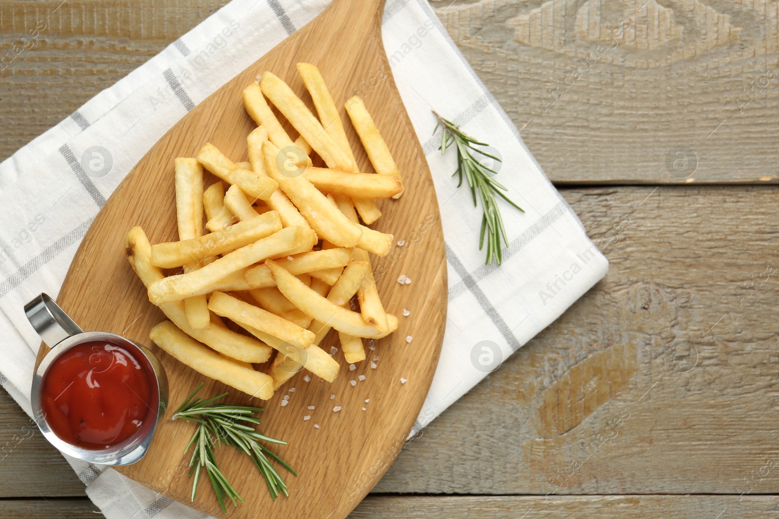 Tasty french fries with ketchup and rosemary on wooden table, top view Photo of Tasty french fries with ketchup and rosemary on wooden table, top view
