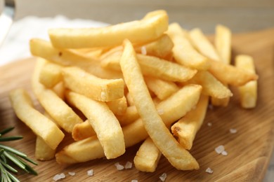 Photo of Fresh tasty french fries on wooden table, closeup