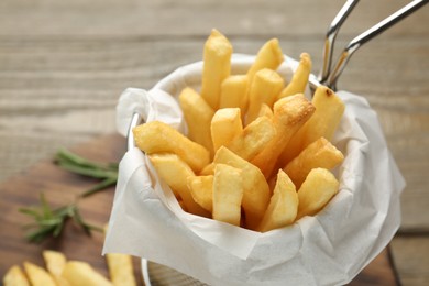 Photo of Tasty french fries on wooden table, closeup