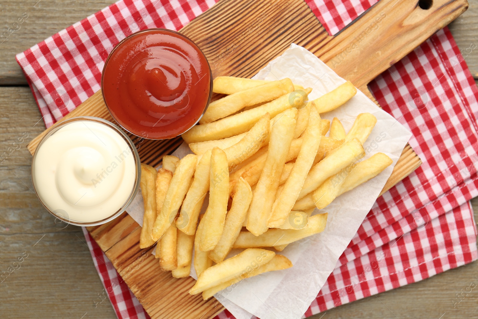 Tasty french fries with sauces on wooden table, top view Photo of Tasty french fries with sauces on wooden table, top view